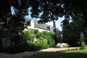 a house with tables and chairs in front of it at Château de la Frégeolière in Theillay