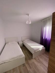 1 Schlafzimmer mit 2 Betten und einem lila Vorhang in der Unterkunft Josep Tarradellas Entire Apartment in Sabadell