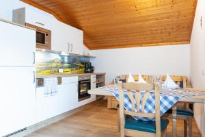 a kitchen with a table and chairs in a room at Appartements Wagnerhaus in Maria Alm am Steinernen Meer