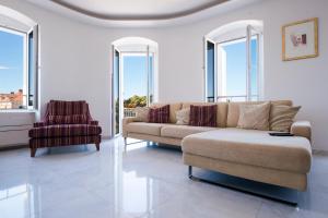 ein Wohnzimmer mit einem Sofa und einem Stuhl in der Unterkunft LUXURY APARTMENt DRAGA in Split
