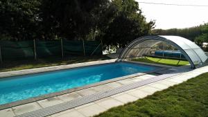 a swimming pool with a cover over it at Chambre d'Hôtes - La Rigaudière in Le Theil-de-Bretagne