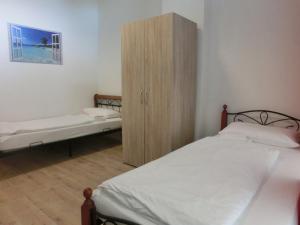 ハンブルクにあるPension Stadtparkのベッドルーム1室(ベッド1台付)、木製キャビネットが備わります。