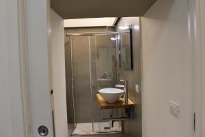 uma casa de banho com uma cabina de duche em vidro e um lavatório. em CIVITAS em Catânia