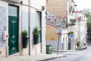 een straat met een groene deur en potplanten op een gebouw bij Lisbon City Center Baixa in Lissabon