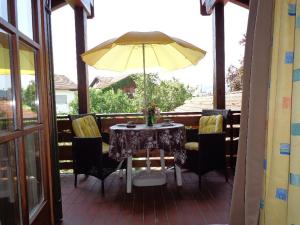 een tafel en stoelen met een gele parasol op een veranda bij Ferienwohnung Burgenblick in Hopferau