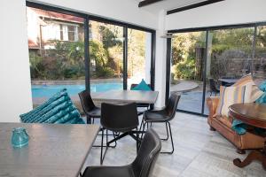eine Terrasse mit Tischen und Stühlen und einem Pool in der Unterkunft Serene Guest Manor in Johannesburg
