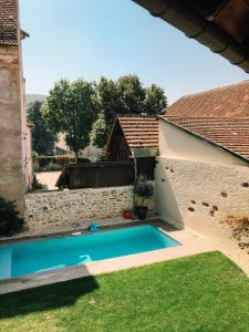 a swimming pool in a yard next to a building at Maison d'hôtes La Rose d'Alsace in Rosheim