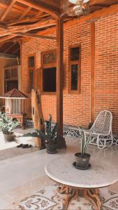 a patio with a table and chairs and a brick wall at Villa Pondok Joglo in Yogyakarta