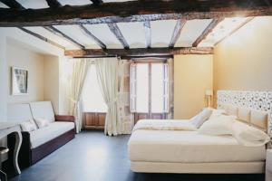 a bedroom with two beds and a couch and a window at Jardín Botánico in Lloreda