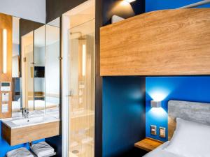 
a bedroom with a bed and a mirror at ibis budget Santiago Providencia in Santiago
