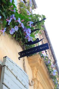 un panneau sur le côté d'un bâtiment avec des fleurs dans l'établissement Le Patio d'Arles, à Arles