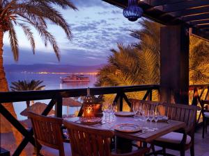 a table on a balcony with a view of the ocean at Mövenpick Resort & Residences Aqaba in Aqaba
