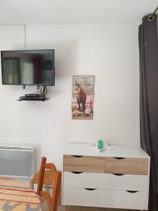 a room with a tv and a desk with a tv at jolie appartement a cauterets in Cauterets