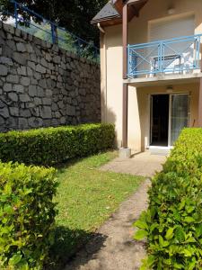 una casa con un muro in pietra e un passaggio pedonale di jolie appartement a cauterets a Cauterets