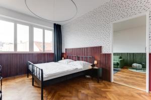 a bedroom with a bed and a large window at Apartment Petrska in Prague