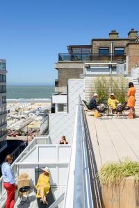 a group of people sitting on the roof of a building at Hotel Nelson in Knokke-Heist