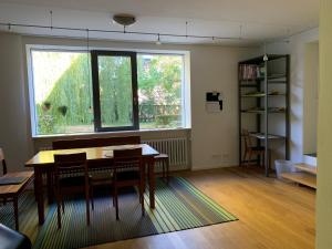 une chambre avec une table, des chaises et une fenêtre dans l'établissement F80-Die FEINE Ferienwohnung, à Ratisbonne