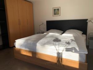 ein Schlafzimmer mit einem Bett mit weißer Bettwäsche und Blumen darauf in der Unterkunft F80-Die FEINE Ferienwohnung in Regensburg