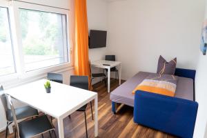 Cette petite chambre comprend un lit et une table. dans l'établissement Anstatthotel Schafisheim - self-check-in, à Schafisheim