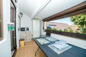 a small balcony with a table and a window at Vila Anastasia in Mangalia