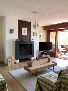 sala de estar con chimenea y mesa de centro en Renovated Mountain View Apartment - Les Eperviers, en Crans-Montana