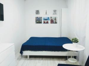 クラスノダールにあるСтудия Три Столицы у кинотеатра "Аврора"の白いベッドルーム(青いベッド1台、テーブル付)