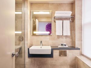 a bathroom with a sink and a mirror and towels at Exeter Rougemont Hotel by Sunday in Exeter +49 photos