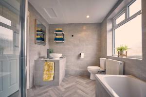 a bathroom with a tub and a toilet and a sink at Host & Stay - Silverlinings in Seaton Delaval