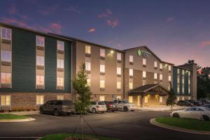 a hotel with cars parked in a parking lot at WoodSpring Suites Atlanta McDonough in McDonough