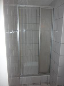 a shower with a glass door in a bathroom at Buch-Ein-Bett Hostel in Hamburg