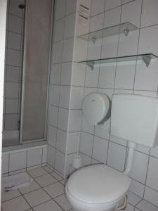 a white bathroom with a toilet and a shower at Buch-Ein-Bett Hostel in Hamburg