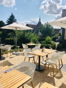 Wyndberg في لونبورغ: فناء به طاولات وكراسي بيضاء ومظلات