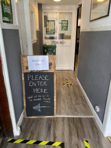 a hallway with a chalkboard sign on the floor at The Black Swan Hotel in Kelso