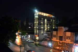 a tall building with lights on in a city at night at Hotel Dayal in Udaipur