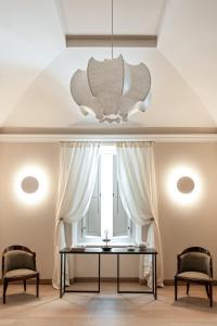 d'une salle à manger avec une table, deux chaises et une fenêtre. dans l'établissement Dimora Fortebraccio, à LʼAquila