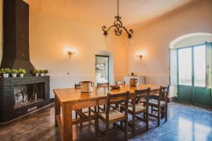 uma sala de jantar com uma mesa e cadeiras e uma lareira em Casale 1818 Resort em Chiaramonte Gulfi