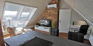 a living room with a couch and a tv in a loft at Ferienwohnungen "Am Berge" in Sachsenhausen