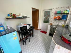 a kitchen with a blue refrigerator and a microwave at เพียงภูโฮมสเตย์ in Sattahip