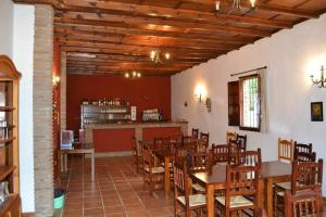 a restaurant with wooden tables and chairs and a counter at Albergue Rural de Fuente Agria in Villafranca de Córdoba