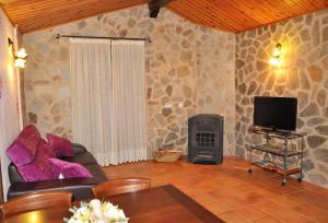 a living room with a couch and a television at Serrania - Apartamentos El Cabo in Las Majadas