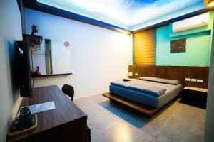 a bedroom with a bed and a table and a desk at Ryan's Guesthouse in Xiyu