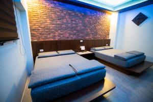 a room with two beds and a brick wall at Ryan's Guesthouse in Xiyu