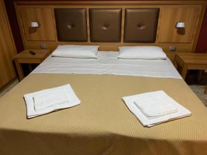Una cama con dos toallas blancas encima. en CASA VACANZE LINA, en San Mauro Castelverde