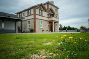 a house with a lawn with flowers in front of it at Ryan's Guesthouse in Xiyu