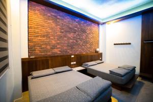 a room with two beds and a brick wall at Ryan's Guesthouse in Xiyu