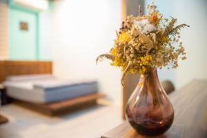 a vase with flowers in it sitting on a table at Ryan's Guesthouse in Xiyu