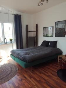 a bedroom with a bed and a wooden floor at Gårdshuset in Söderhamn