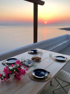 uma mesa com pratos de comida e flores em Dammuso sulla scogliera - Pantelleria em Scauri