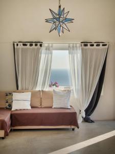 een slaapkamer met een bed en een raam met uitzicht op de oceaan bij Dammuso sulla scogliera - Pantelleria in Scauri