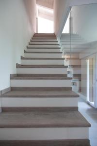 una scala in una casa con pareti bianche e pavimenti in legno di Villa Felice a San Giovanni in Marignano